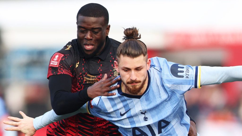 Tamworth striker Chris Wreh battles with Tottenham defender Radu Dragusin