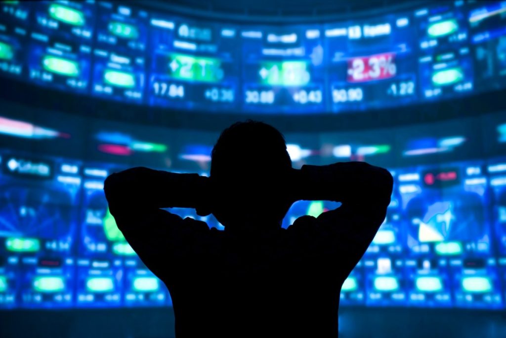 young man standing in front of the projection reflected stock market