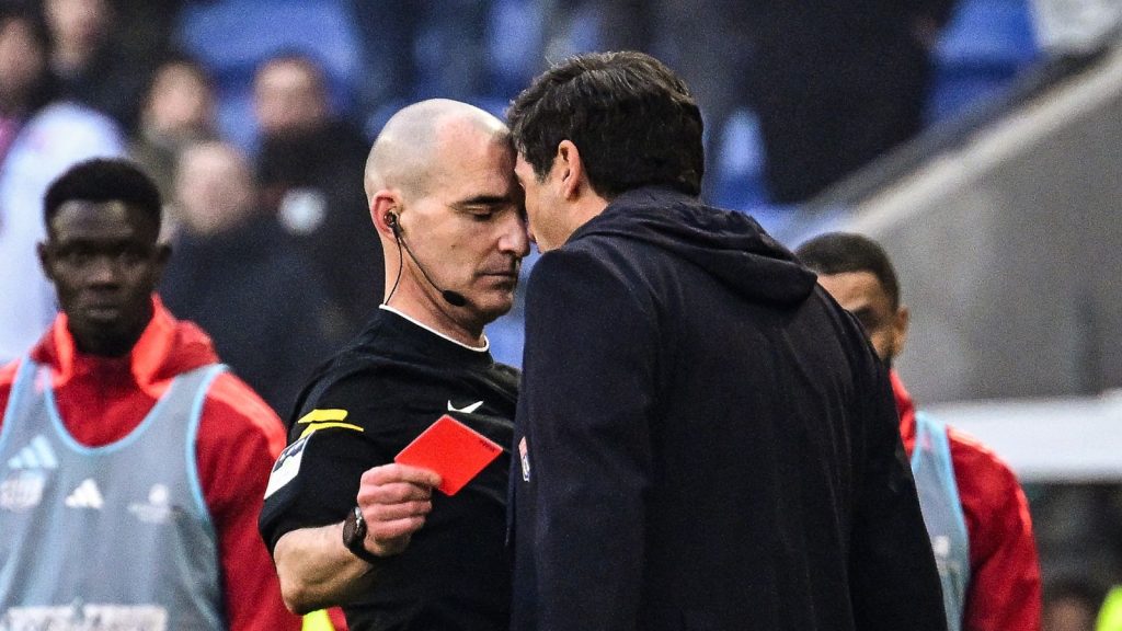 Paulo Fonseca (R) yells at French referee Benoit Millot after receiving a red card